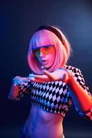 Portrait of young girl with blond hair in eyeglasses in red and blue neon in studio photo