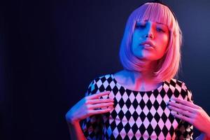 Portrait of young girl with blond hair in red and blue neon in studio photo