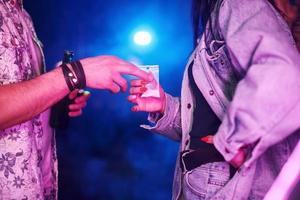 Young girl buying drugs inside of night club at party time photo