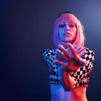 Portrait of young girl with blond hair in red and blue neon in studio photo