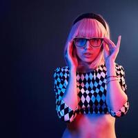 retrato de una joven con el pelo rubio en anteojos de neón rojo y azul en el estudio foto