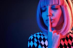 Portrait of young girl with blond hair in red and blue neon in studio photo