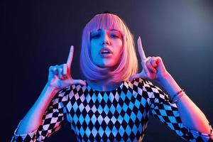 Portrait of young girl with blond hair in red and blue neon in studio photo