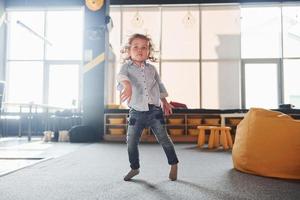 Child in casual clothes have fun in playroom at weekend time photo