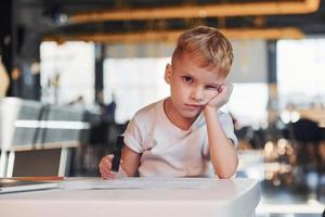 Smart child in casual clothes with laptop on table have fun photo