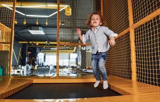 Child in casual clothes have fun in playroom at weekend time photo