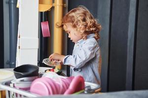 el niño con ropa informal se divierte aprendiendo a preparar la comida foto