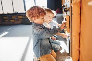 Children have fun in playroom near the wall. Kindergarten educational games photo