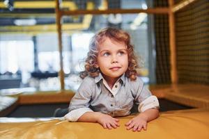 Child sitting in playroom. Kindergarten educational games photo