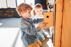 Children have fun in playroom near the wall. Kindergarten educational games photo