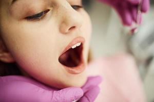 niña visitando al dentista en la clínica. concepción de la estomatología foto