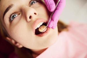 niña visitando al dentista en la clínica. concepción de la estomatología foto