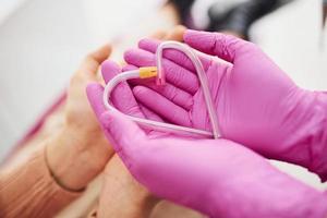 Hands in gloves holding heart shaped clinical pipes photo