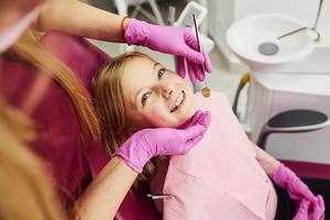 niña visitando al dentista en la clínica. concepción de la estomatología foto