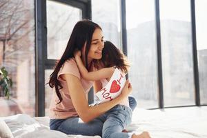 Embracing each other. Daughter congratulates mother with holiday and gives post card photo