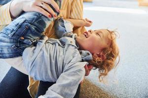 Child in jeans and casual clothes have fun indoors photo