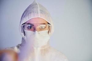 Portrait of female doctor scientist in lab coat, defensive eyewear and mask photo