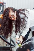 mujer con equipo de limpieza de automóviles modernos. concepto de servicio foto