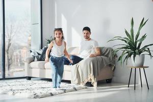 Happy father with his daughter spending free time with laptop at home together photo