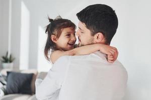 padre feliz con su hija abrazándose en casa foto