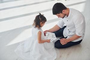 feliz Día del Padre. la hija le hace una sorpresa a papá al darle una postal con el corazón foto