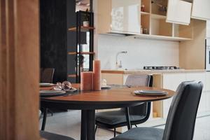 Interior of modern new kitchen with table and candles with plates on it photo