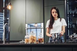 Preparing fresh food. Young beautiful brunette in casual clothes indoors in kitchen at daytime photo