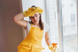 Tired housewife in yellow uniform takes a break indoors. House renovation conception photo