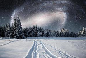 majestuoso paisaje con bosque en la noche de invierno con estrellas y galaxias en el cielo. fondo del paisaje. elementos proporcionados por la nasa foto