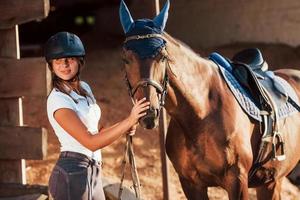 Animal is in blue clothes. Horsewoman in uniform and black protective helmet with her horse photo