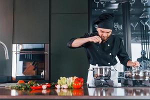 Professional young chef cook in uniform have a busy day on the kitchen photo