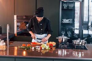 Professional young chef cook in uniform working on the kitchen photo