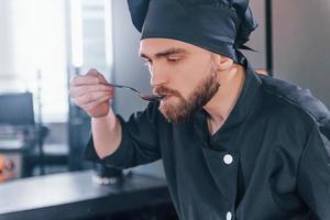 Professional young chef cook in uniform working on the kitchen photo