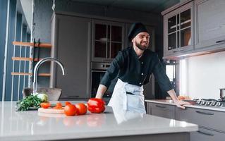 Professional young chef cook in uniform making salad on the kitchen photo