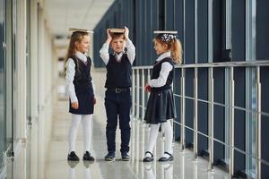 School kids in uniform together with books in corridor. Conception of education photo