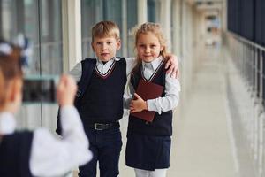 escolares en uniforme haciendo una foto juntos en el pasillo. concepción de la educación