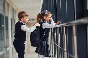 A little schoolboy steals things from a girl's bag while she is listening to music photo