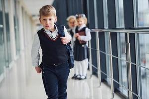 escolares en uniforme juntos en el pasillo. concepción de la educación foto