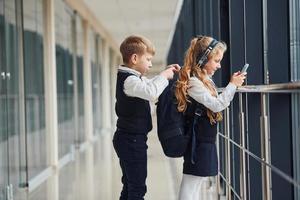 A little schoolboy steals things from a girl's bag while she is listening to music photo