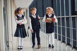 School kids in uniform together in corridor. Conception of education photo