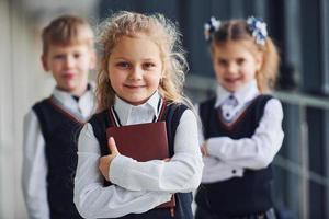 escolares en uniforme junto con libros en el pasillo. concepción de la educación foto