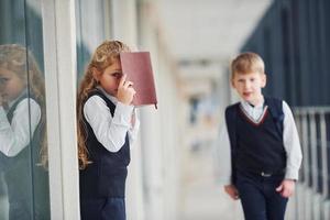 escolares en uniforme con libros juntos en el pasillo. concepción de la educación foto