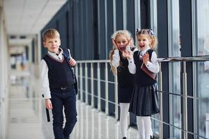 escolares en uniforme juntos en el pasillo. concepción de la educación foto