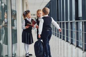 School kids in uniform together in corridor. Conception of education photo