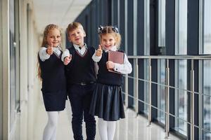 escolares en uniforme juntos en el pasillo. concepción de la educación foto