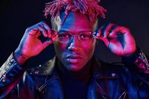 divirtiéndose. iluminación de neón futurista. joven afroamericano en el estudio foto