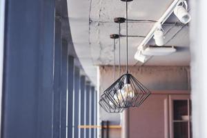 Interior of modern kitchen with light bulbs hanging indoors at daytime photo