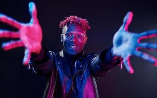 Having fun. Futuristic neon lighting. Young african american man in the studio photo