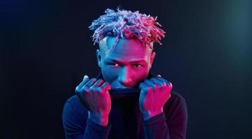 Futuristic neon lighting. Young african american man in the studio photo