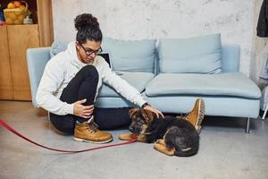 Handsome young man with curly black hair indoors with cute dog photo